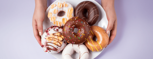 A Picture of Leftover Donuts on a Plate Held By Lady Hands